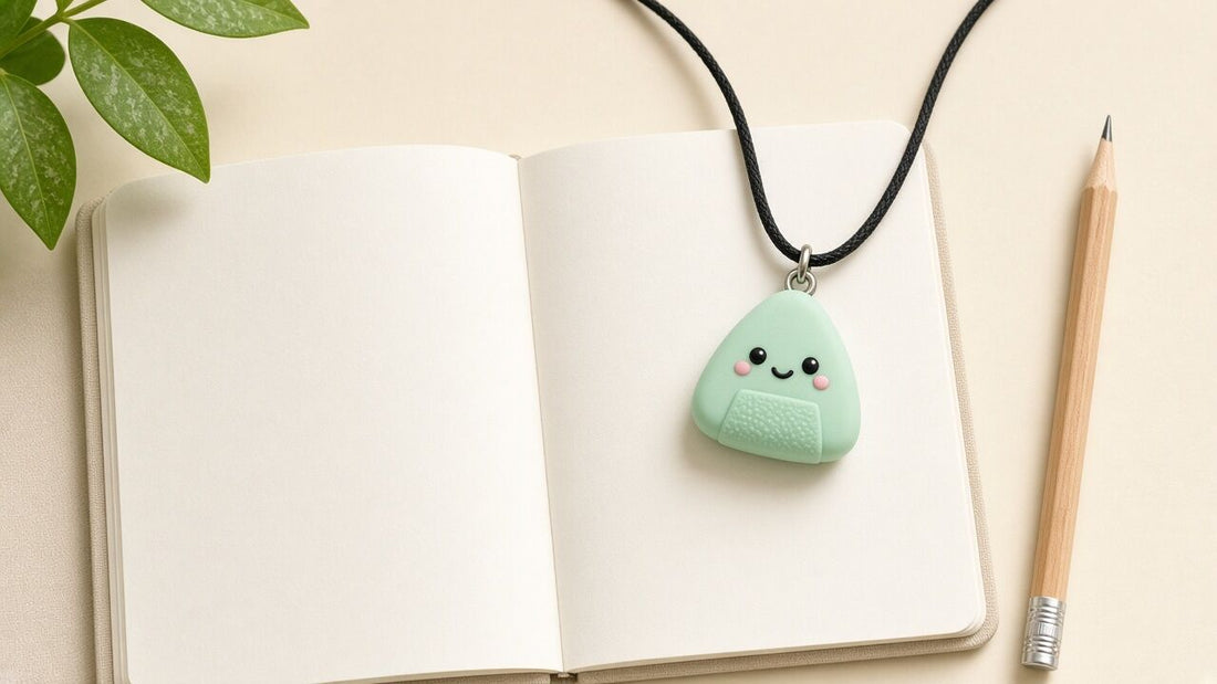 Collier à mâcher onigiri menthe posé sur un carnet ouvert, illustration du mot chewelry