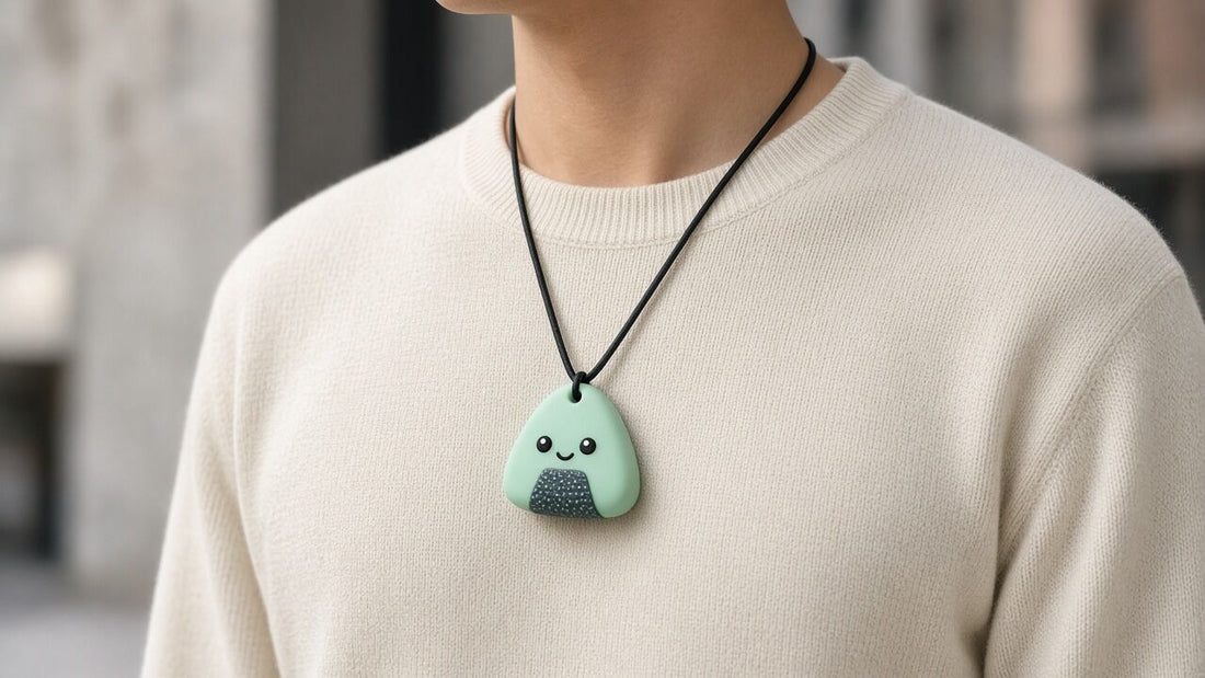 Adulte portant un collier à mâcher onigiri menthe sur un pull uni