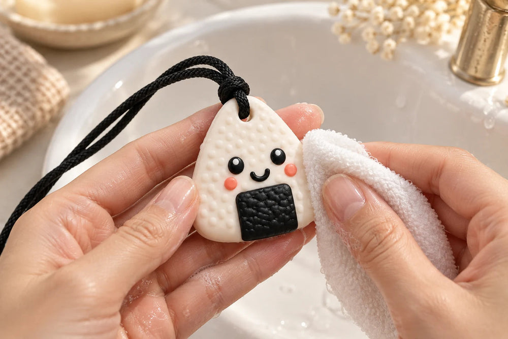 Illustration du nettoyage du pendentif Machouya blanc avec des mains adultes